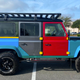 A photo of a Land Rover Defender 110 painted in many different colors.